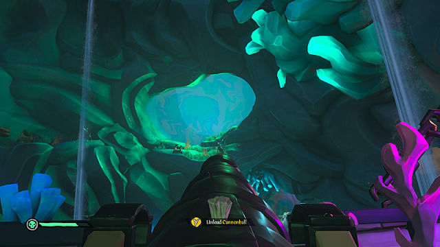 A pirate ship cannon aimed at a large opening in the cave ceiling.